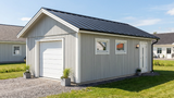 Attefallsgarage med vit garageport, sidodörr och fönster, svart takplåt