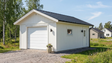 Enkelgarage med grå sidoklädsel, vit garageport och mörkt sadeltak.